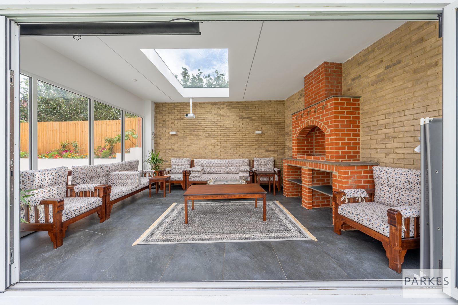Living room with an exposed brick fireplace opening to the garden