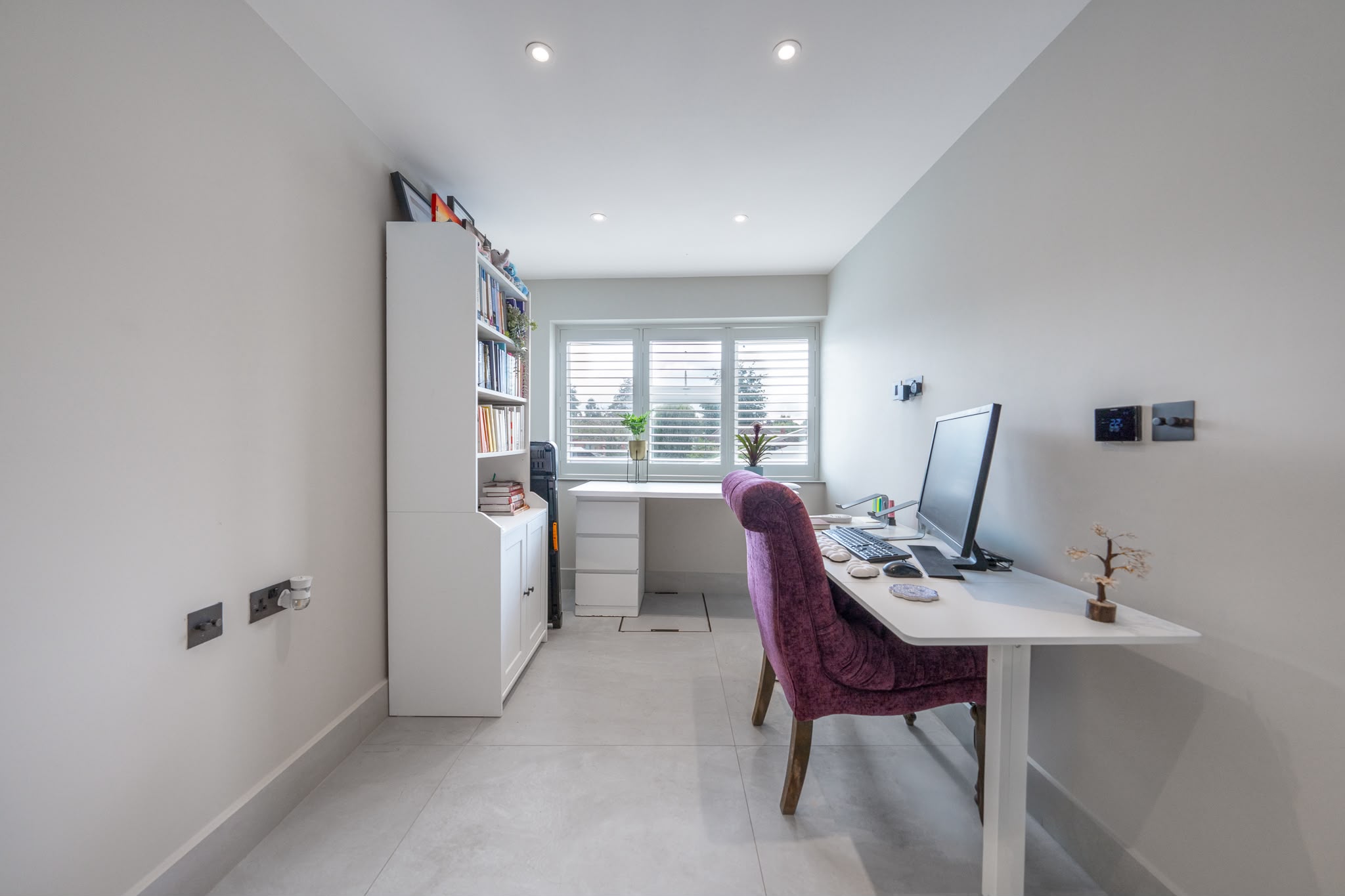 Study lined with bespoke oak shelving and a concealed door